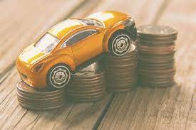 A toy car riding up stacks of coins that are increasing in size. The image symbolizes insurance rates going up