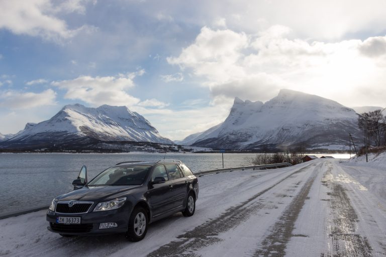 Picture displays a rental car driving through a foreign location in the mountains, showcasing the need for rental car insurance due to known terrain.